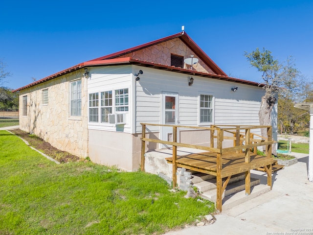 back of house with a deck and a lawn