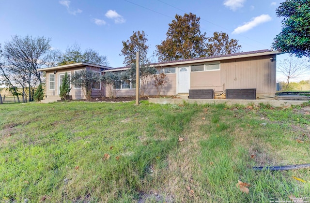 rear view of house featuring a yard