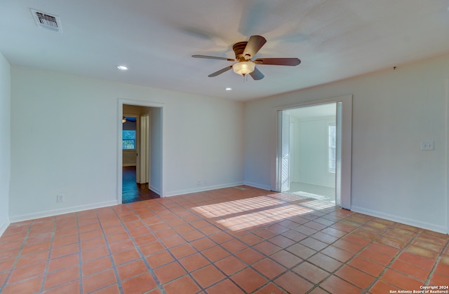 tiled spare room with ceiling fan