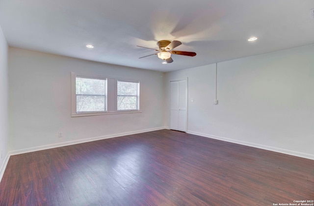 empty room featuring dark wood-type flooring and ceiling fan