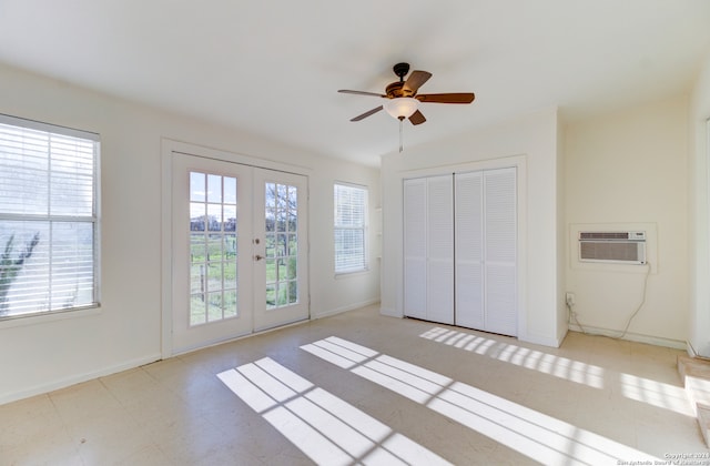 unfurnished bedroom with a closet, light tile flooring, a wall mounted air conditioner, ceiling fan, and french doors