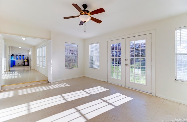 tiled empty room featuring vaulted ceiling, ceiling fan, and french doors