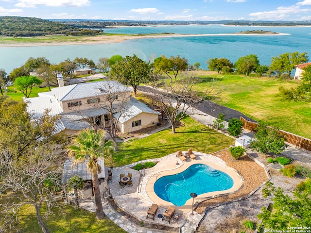 view of swimming pool with a patio, a water view, and a yard