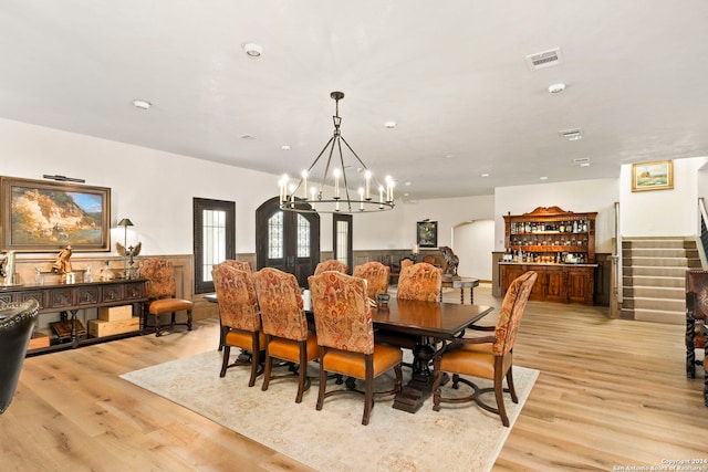 dining space with light hardwood / wood-style floors and a chandelier