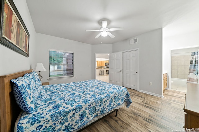 bedroom with a closet, ceiling fan, light hardwood / wood-style floors, and ensuite bathroom