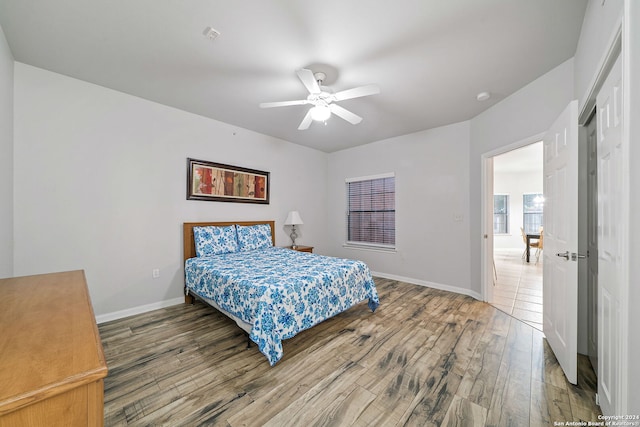 bedroom with hardwood / wood-style floors, a closet, and ceiling fan