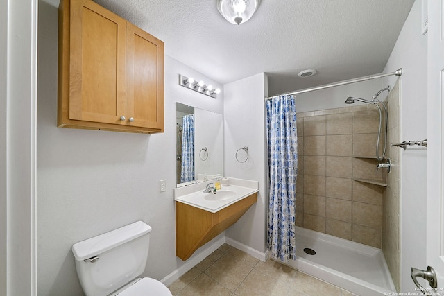 bathroom with tile flooring, vanity with extensive cabinet space, walk in shower, a textured ceiling, and toilet