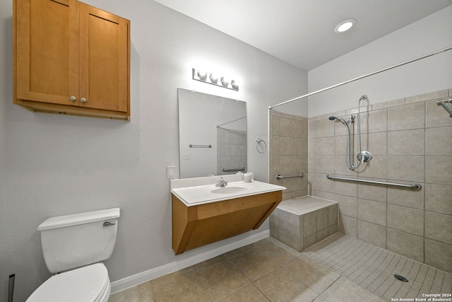 bathroom featuring a tile shower, vanity with extensive cabinet space, toilet, and tile floors