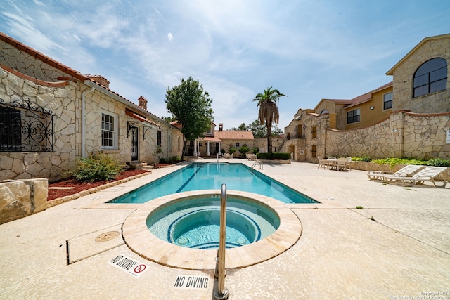 view of swimming pool with a patio and a hot tub