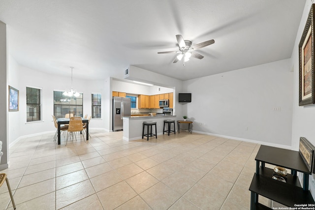 living room featuring light tile flooring and ceiling fan with notable chandelier