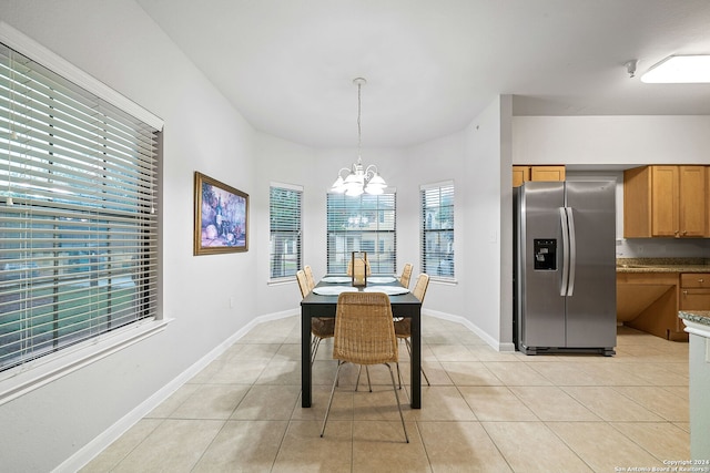 tiled dining room featuring a chandelier and a wealth of natural light