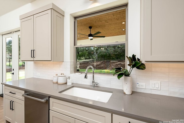 kitchen with backsplash, ceiling fan, white cabinetry, and sink