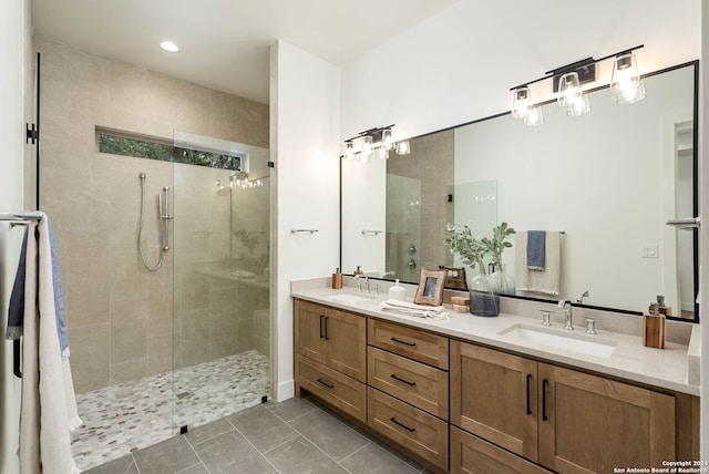 bathroom with tile patterned flooring, vanity, and tiled shower