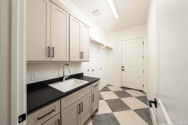 clothes washing area featuring electric dryer hookup, sink, and cabinets