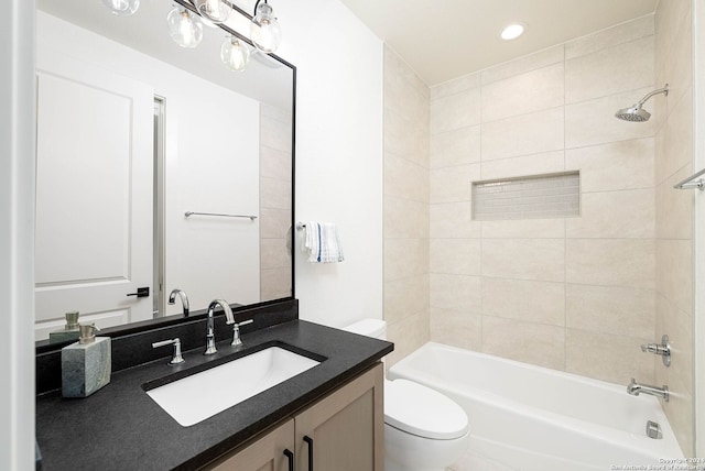 full bathroom featuring vanity, tiled shower / bath combo, and toilet