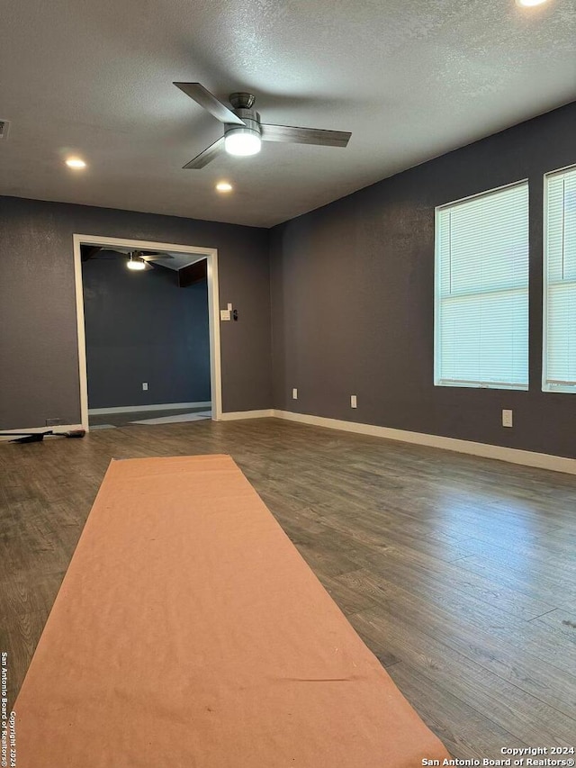 spare room featuring a textured ceiling, ceiling fan, and dark hardwood / wood-style floors