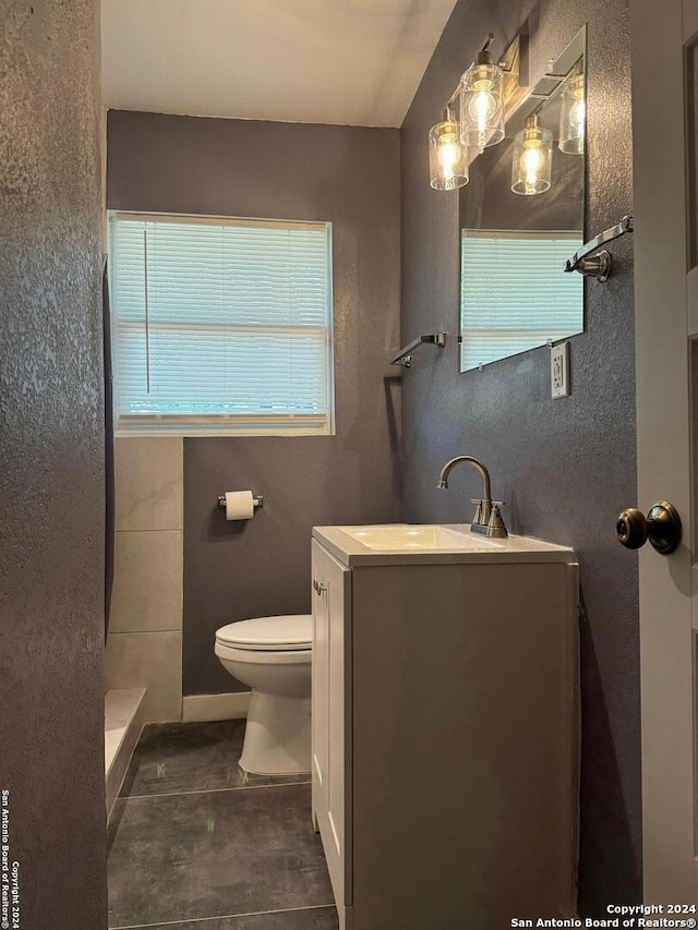 bathroom with tile floors, vanity, and toilet