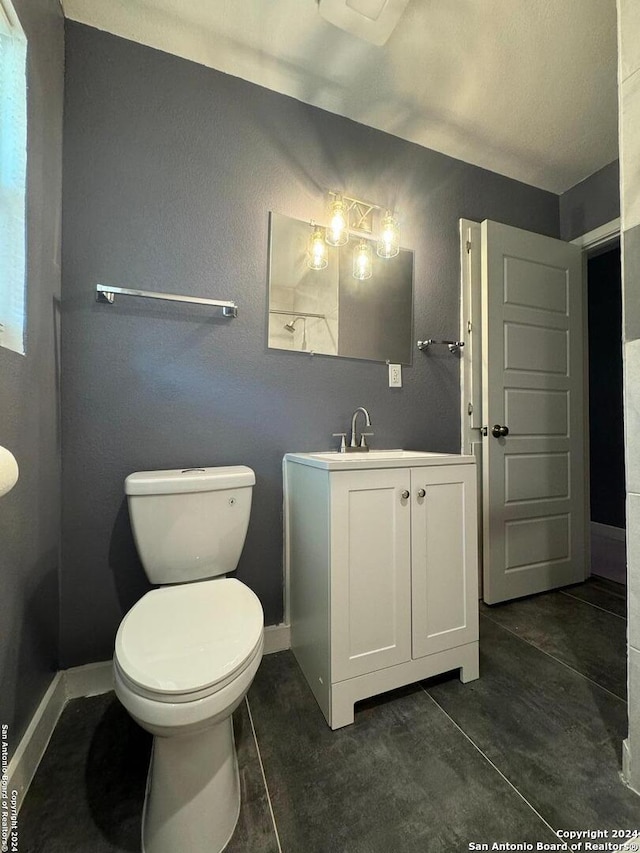 bathroom with tile flooring, vanity, and toilet