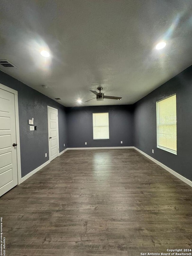 empty room with dark hardwood / wood-style flooring and ceiling fan