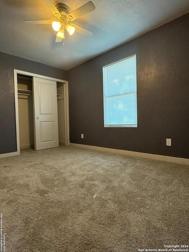 unfurnished bedroom featuring a closet, carpet floors, and ceiling fan