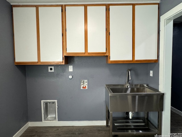 washroom with hookup for an electric dryer, hardwood / wood-style flooring, and cabinets