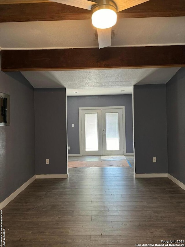 interior space with ceiling fan, french doors, beamed ceiling, wood-type flooring, and a textured ceiling