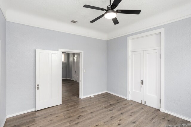 unfurnished bedroom featuring ceiling fan, a closet, and dark wood-type flooring