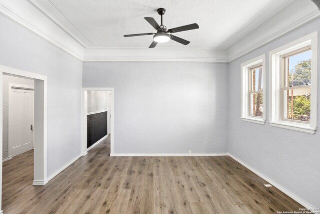 empty room with crown molding, ceiling fan, wood-type flooring, and a textured ceiling