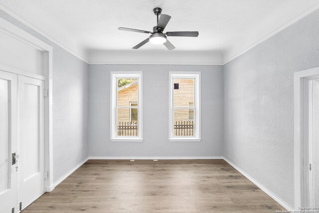 spare room with light hardwood / wood-style floors, ceiling fan, and crown molding