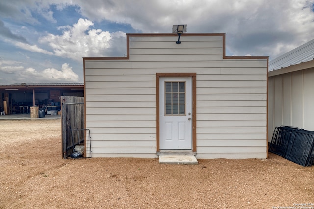 rear view of house featuring an outdoor structure