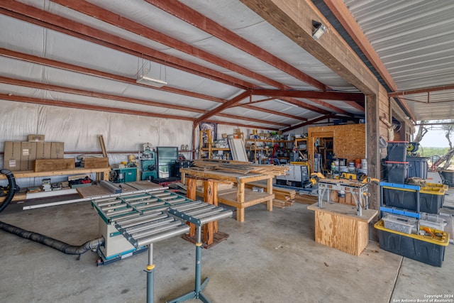 misc room with concrete flooring, a workshop area, and vaulted ceiling