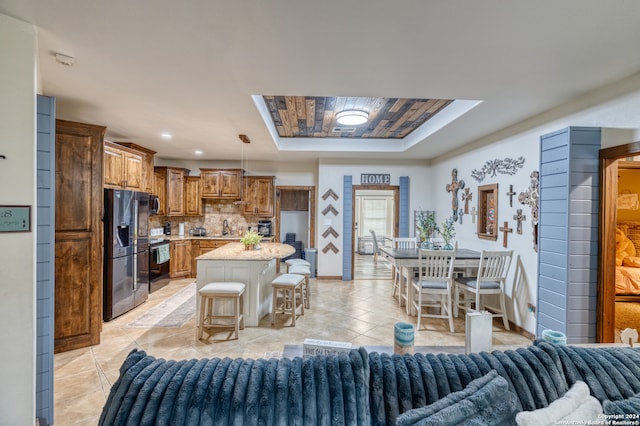 tiled living room with sink, wood ceiling, and a raised ceiling