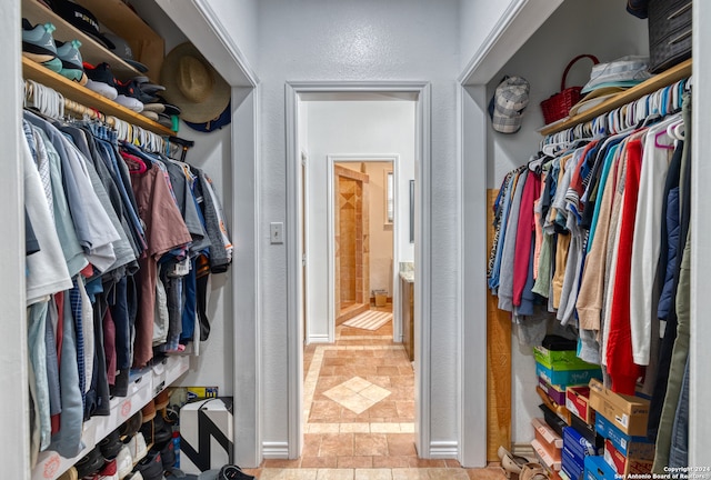 walk in closet with light tile floors