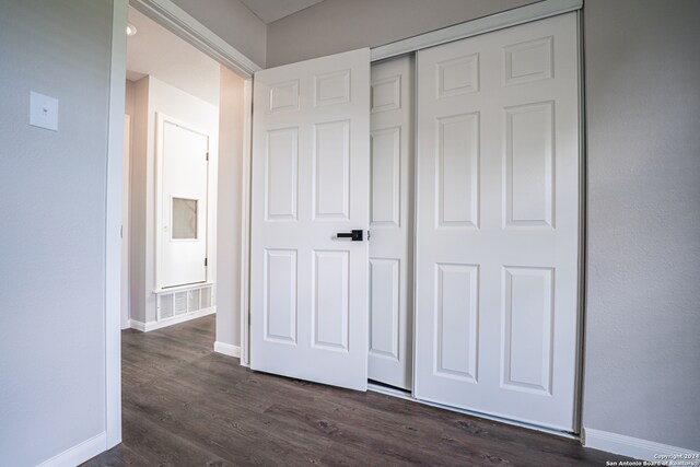 unfurnished bedroom with dark wood-type flooring and a closet