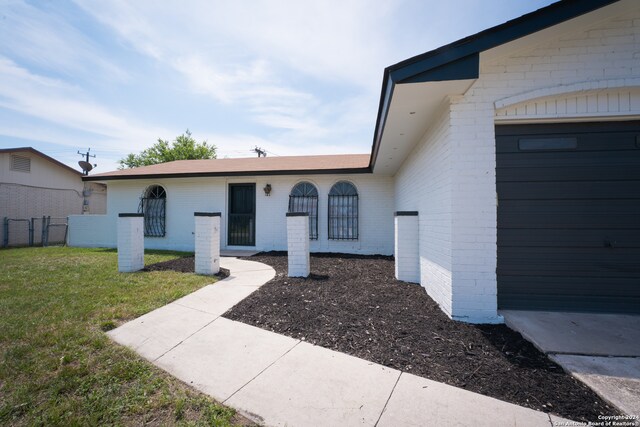 entrance to property featuring a lawn