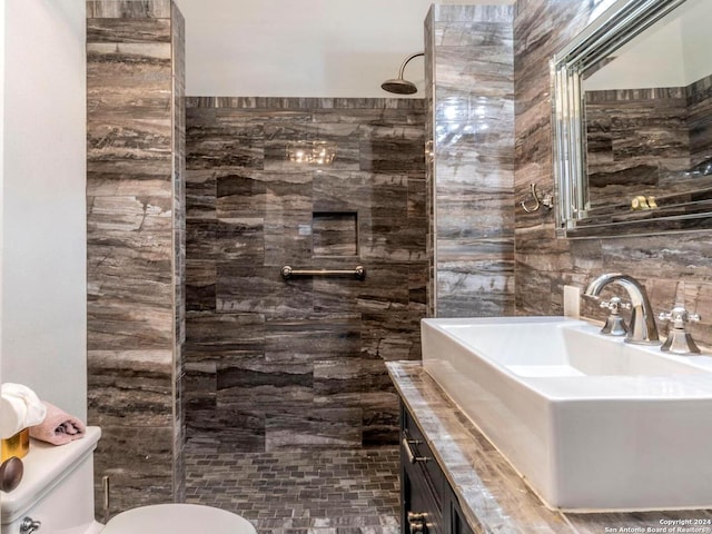 bathroom featuring tiled shower, vanity, and toilet