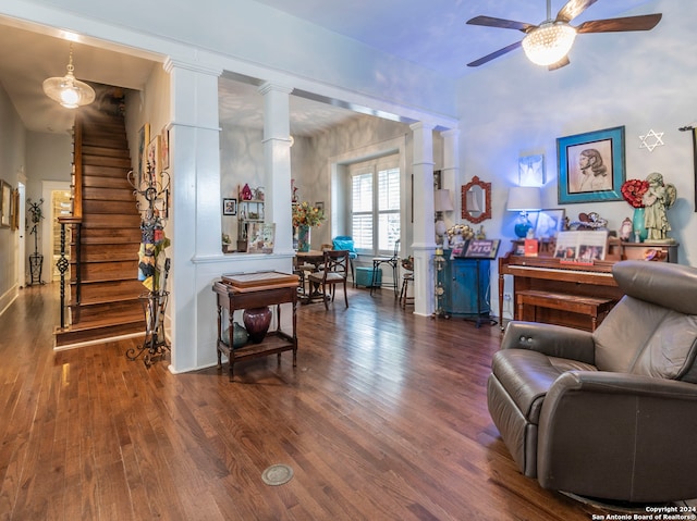 living area featuring ornate columns, ceiling fan, and dark hardwood / wood-style floors