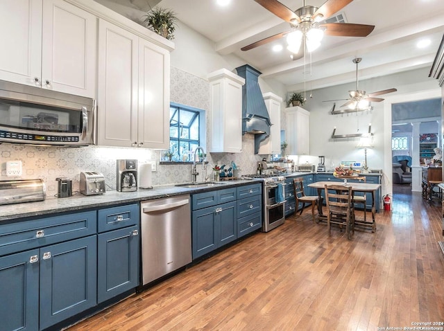 kitchen featuring white cabinets, sink, hardwood / wood-style flooring, blue cabinetry, and stainless steel appliances