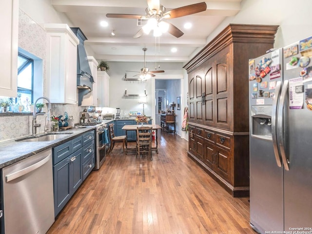 kitchen featuring backsplash, stainless steel appliances, sink, hardwood / wood-style floors, and white cabinetry