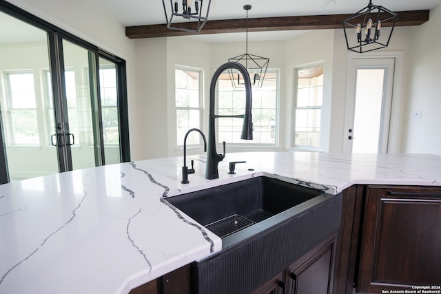 kitchen with a healthy amount of sunlight, sink, beamed ceiling, and hanging light fixtures