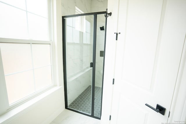 bathroom with plenty of natural light and a shower with shower door