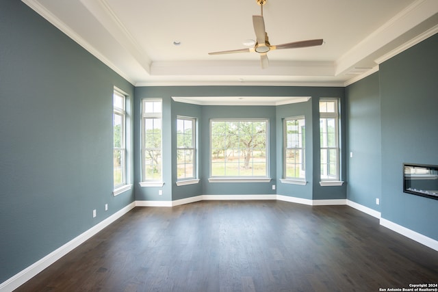 unfurnished room with dark hardwood / wood-style flooring, a raised ceiling, ceiling fan, and ornamental molding