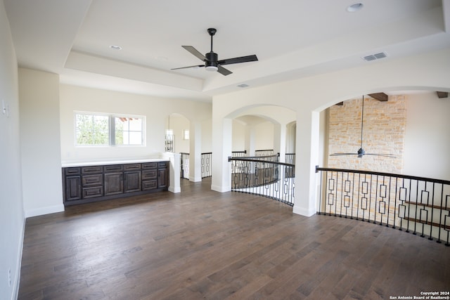 interior space featuring ceiling fan, dark hardwood / wood-style flooring, and a raised ceiling