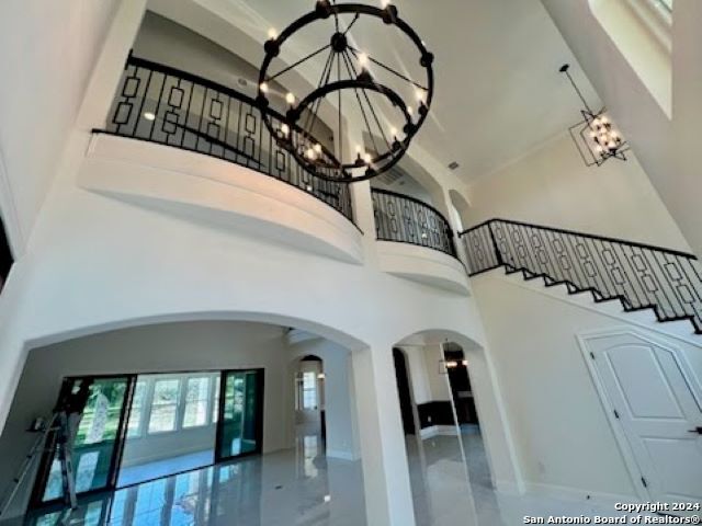 stairs featuring a high ceiling and a notable chandelier