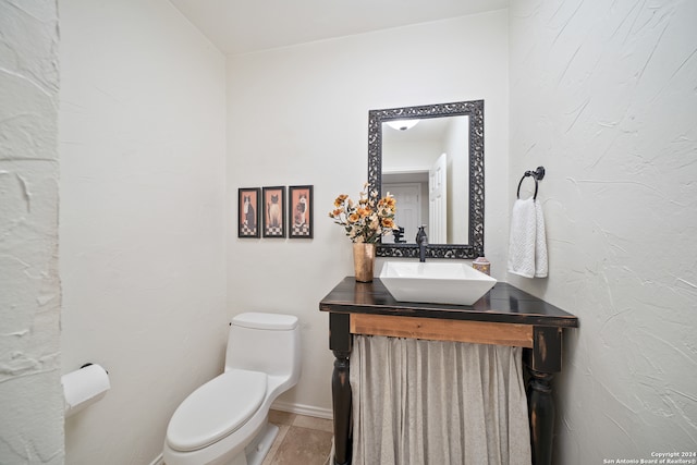 bathroom featuring tile flooring, toilet, and vanity