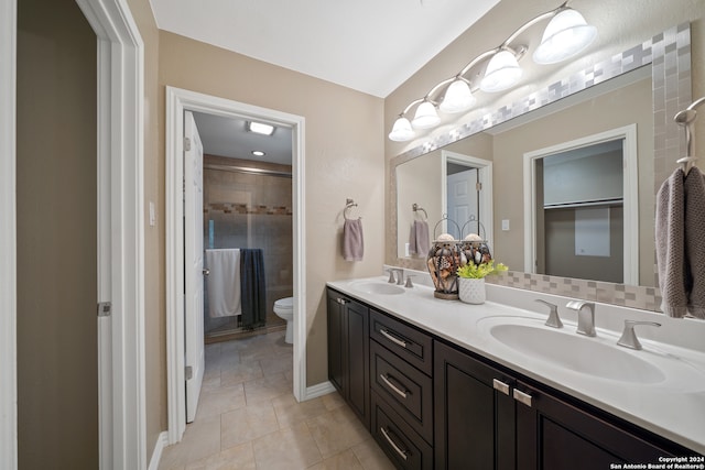 bathroom featuring double vanity, tile flooring, and toilet