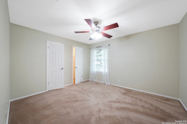 carpeted spare room featuring ceiling fan