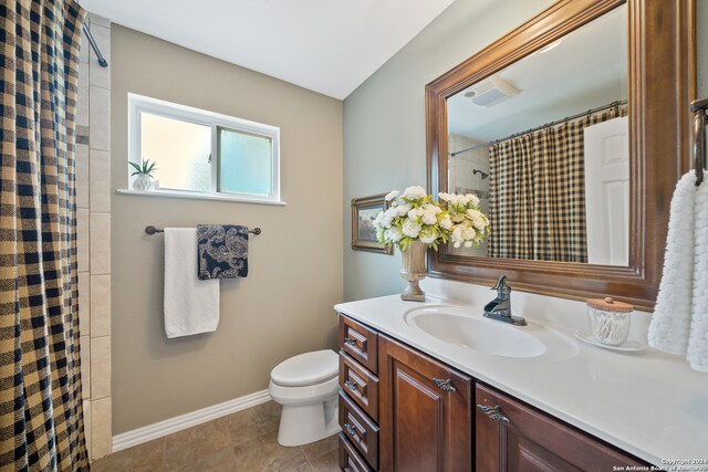 bathroom with tile flooring, vanity, and toilet