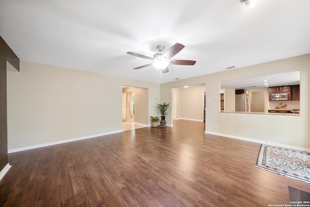 unfurnished living room featuring hardwood / wood-style flooring and ceiling fan