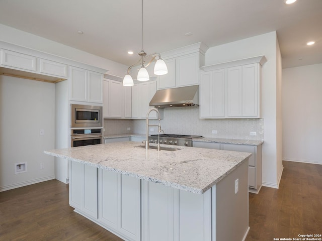 kitchen with stainless steel appliances, dark hardwood / wood-style flooring, a center island with sink, and pendant lighting